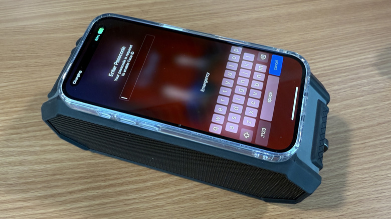 A phone on top of a speaker charging wirelessly