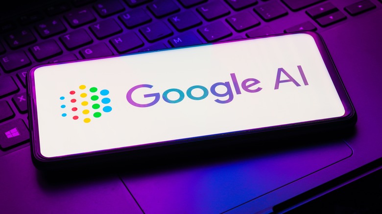 Google AI logo on a phone resting on a laptop