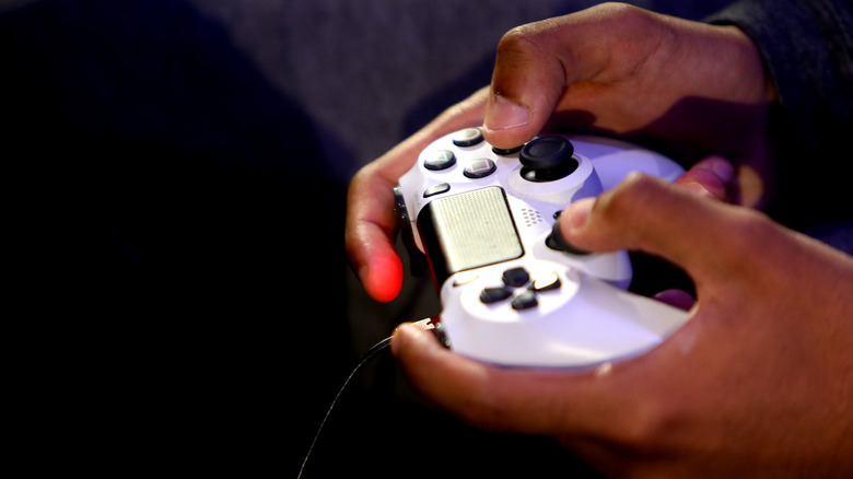 person holding white ps4 controller