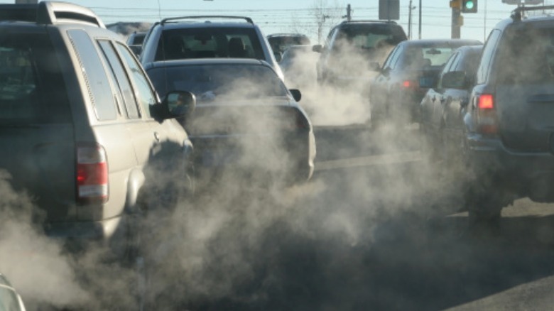 cars in traffic emitting lots of exhaust smoke