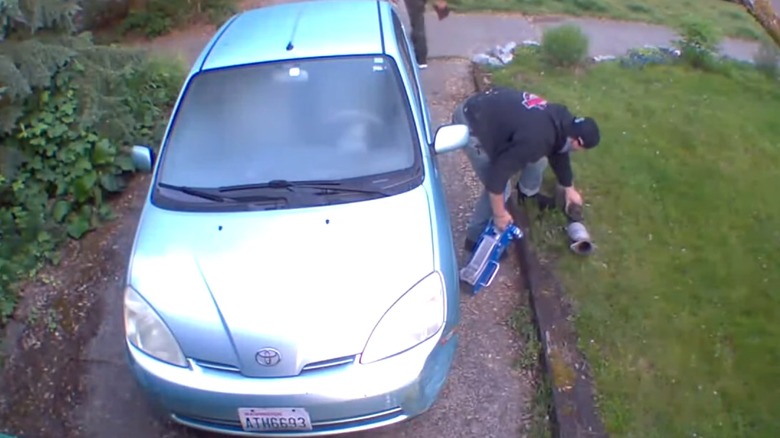 A professional crew stealing a car's catalytic converter