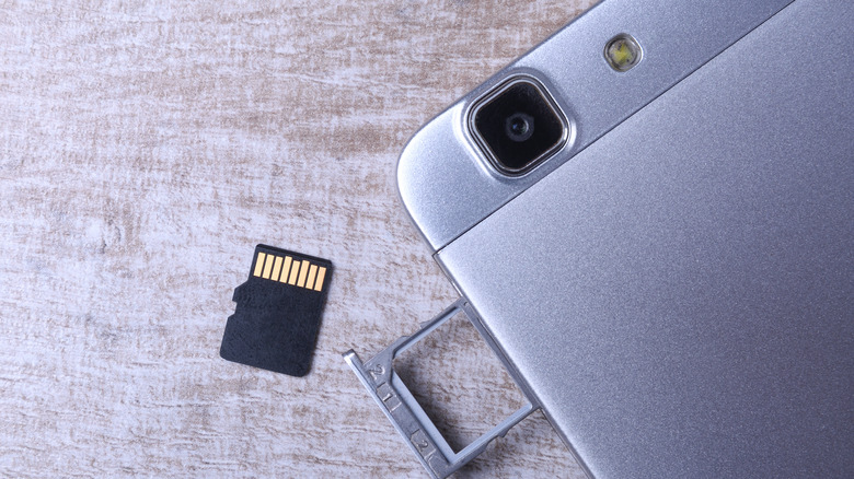 MicroSD card next to a smartphone