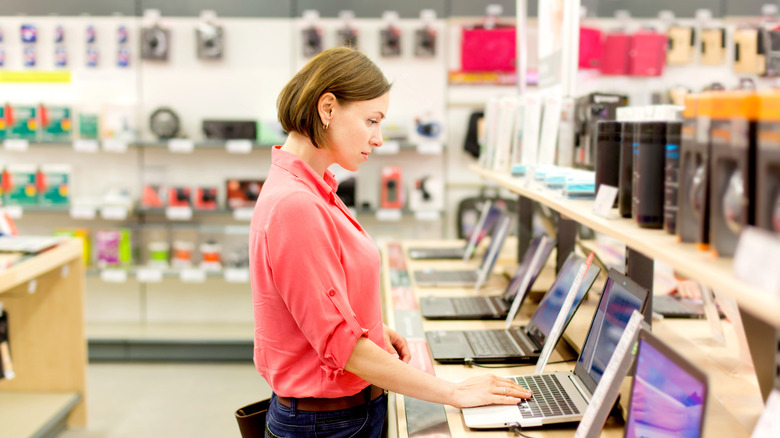 woman choosing a laptop in a store