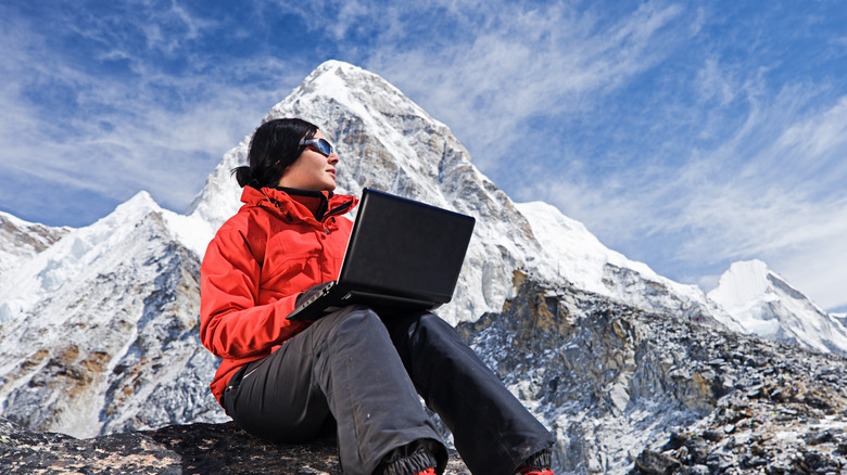 person using laptop in the mountains