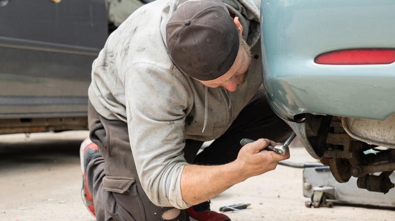 Man working on car's rear mudflap