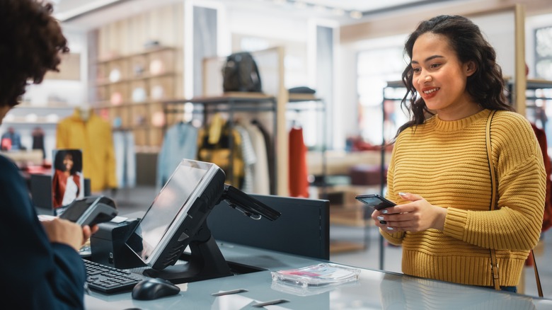 woman paying with her phone at a store