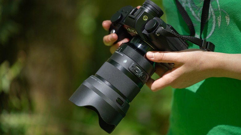 Leica SL3 and the Sigma 50mm f/1.2 Art in a woman's hands.