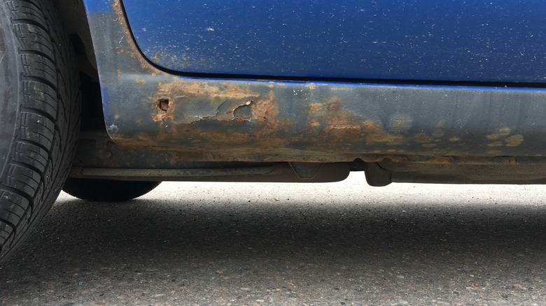 A vehicle's rocker panel showing signs of rust