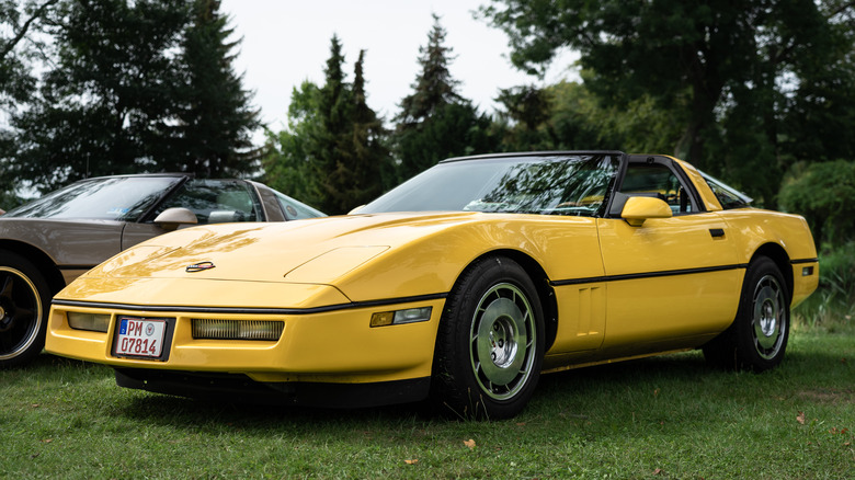 Yellow C4 Corvette targa top parked on grass