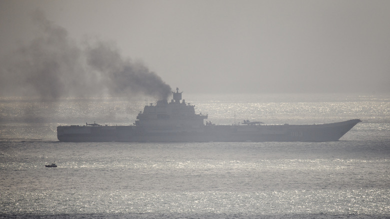 Russian aircraft cruiser Admiral Kuznetsov cruises with black smoke