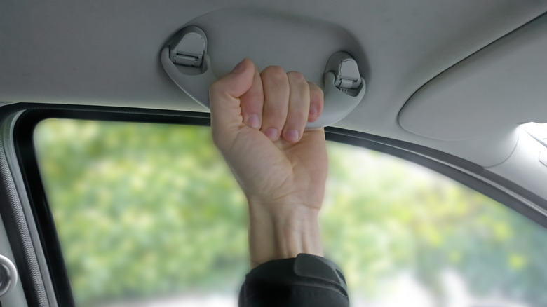 hand holding car door grab handle