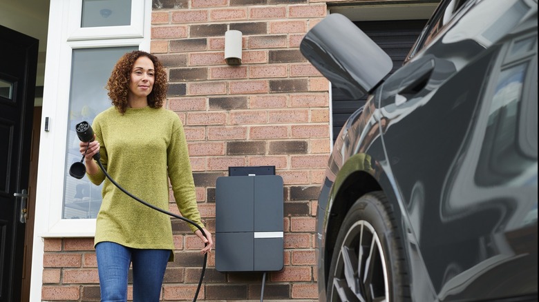 A woman about to charge her EV at home