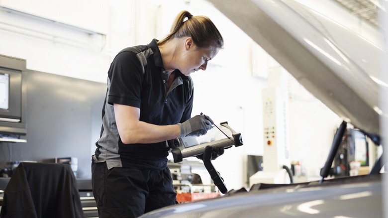 A mechanic inspecting a car.