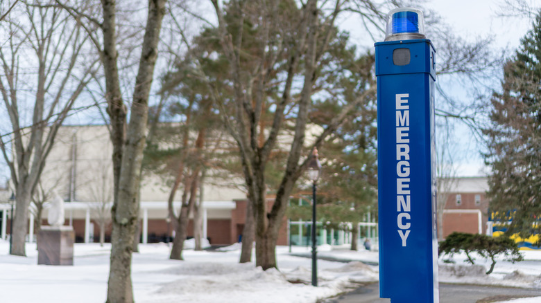 A blue emergency phone light, with blue light, on walkway.