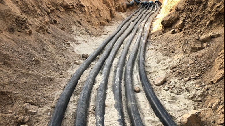 Power cables running through a trench before being buried.