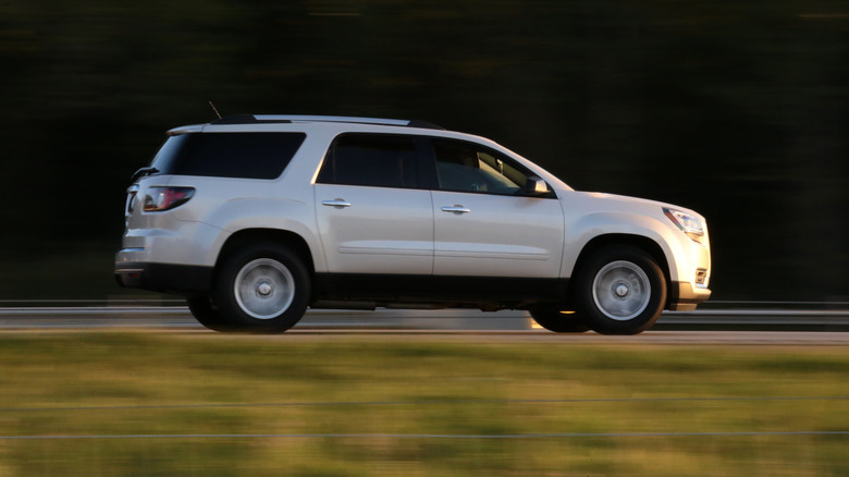 SUV driving fast down a road.