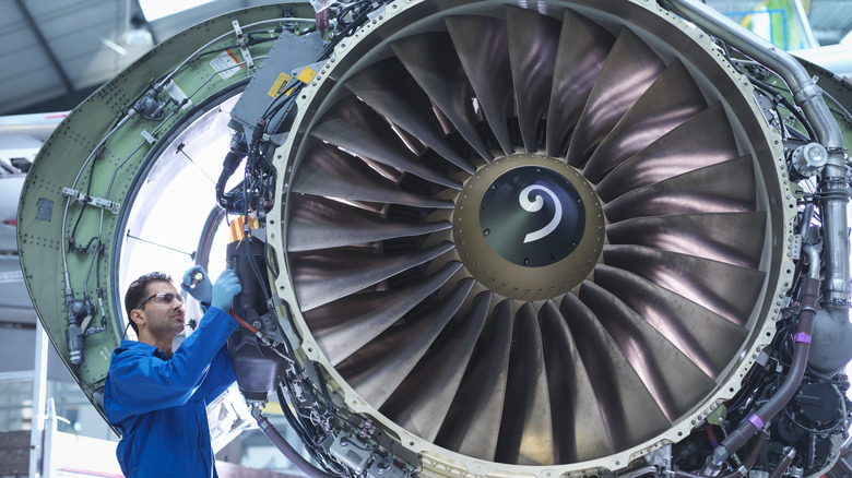 Maintenance worker working on jet engine