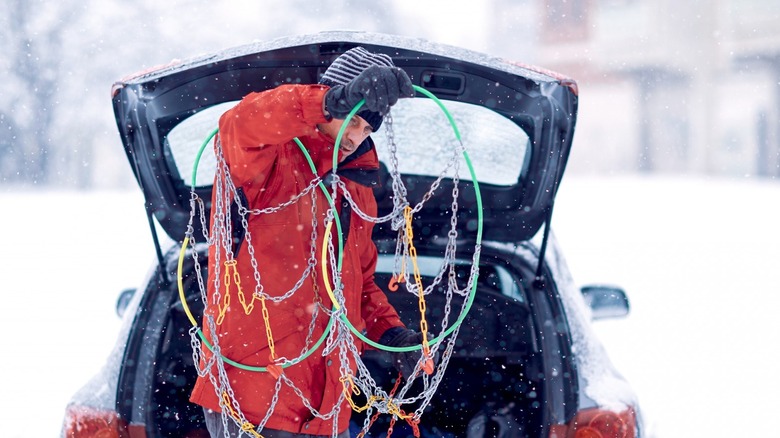 Driver learning how to use tire chains