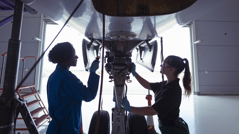 engineers inspecting landing gear