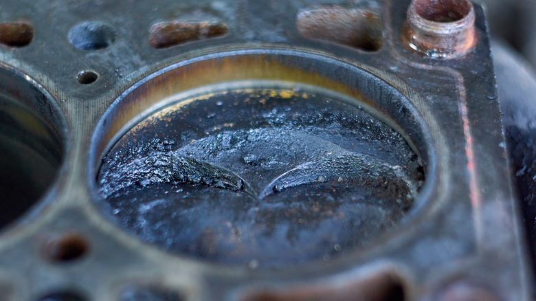 Carbon deposits on an engine piston