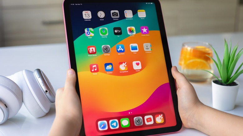 Child holding iPad Pro, with homescreen showing