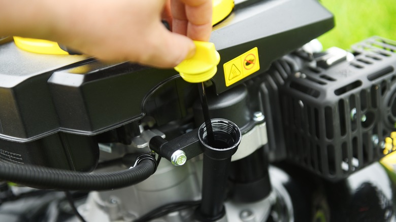 Person checking mower oil level