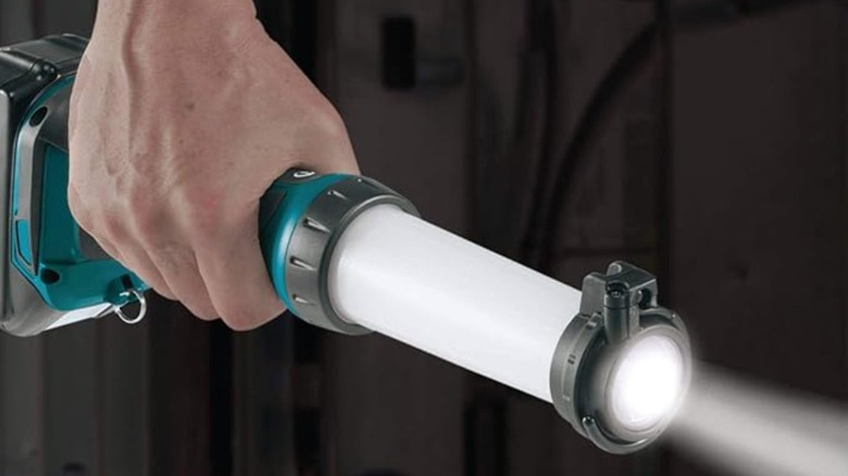 Person holding a Makita flashlight