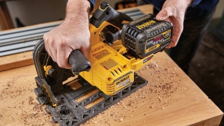 Person holding DeWalt track saw on table