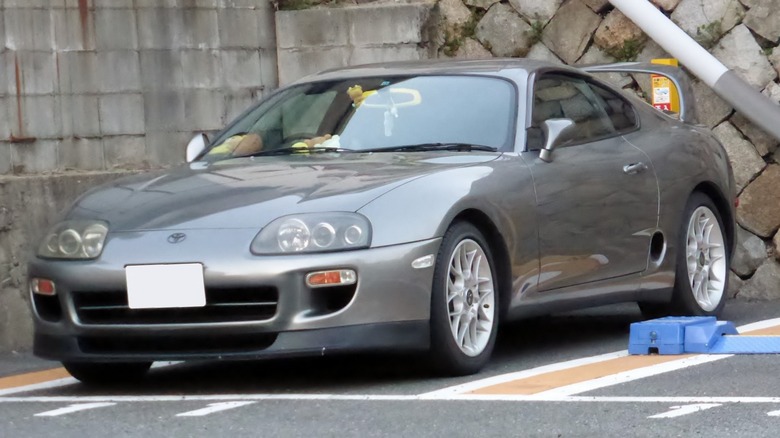 Gray JDM Toyota Supra Mk IV parked in bay.