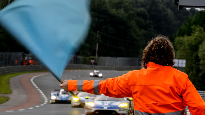 A race official waving the blue flag