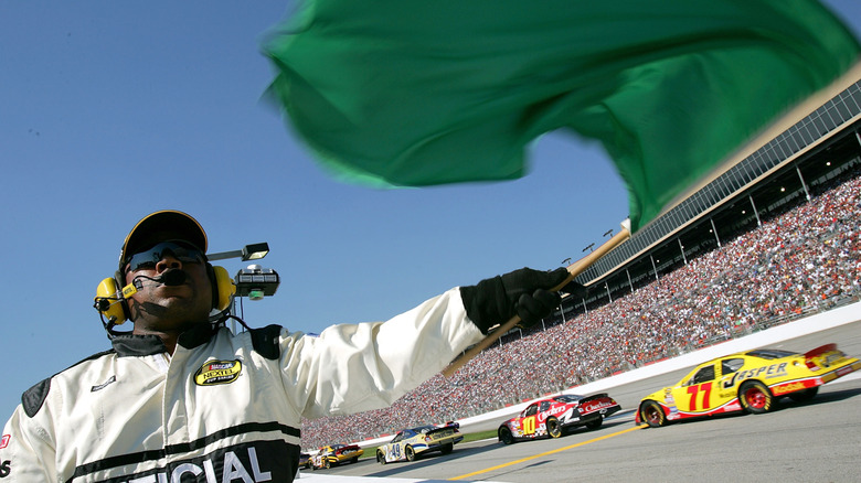 A race official waving the green flag