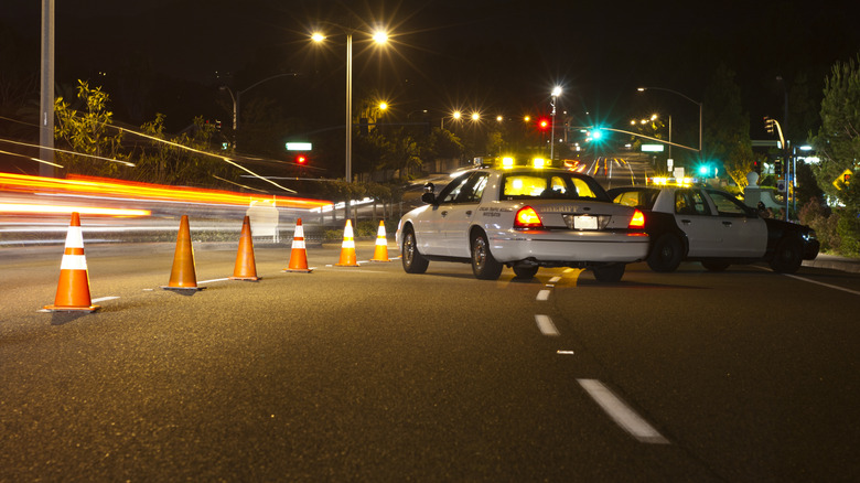 Police cars pulled to the side of the road with yellow lights