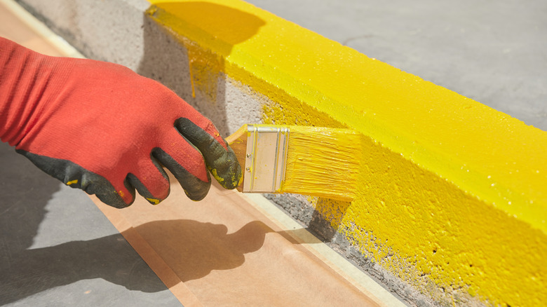 Person painting curb yellow