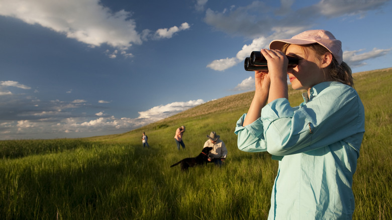 A woman looking through a pair of binoculars