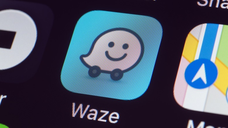 Waze app icon on a smartphone next to Google Maps and Uber.