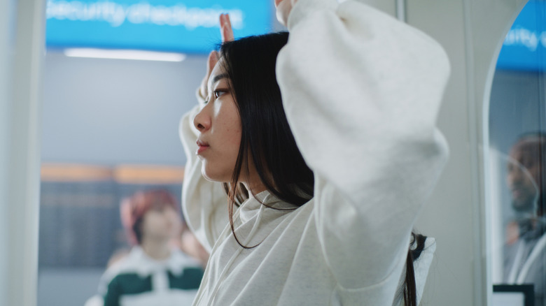 woman getting scanned at airport