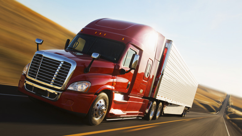 Red semi-truck on an open highway