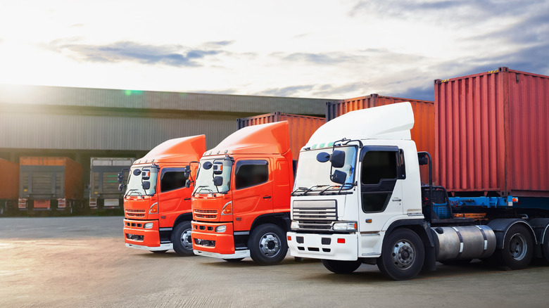 Orange and white semi-truck trailers at a parking deck