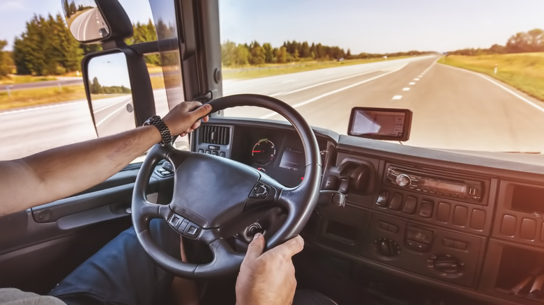 Steering wheel and dashboard of a commercial truck on the road