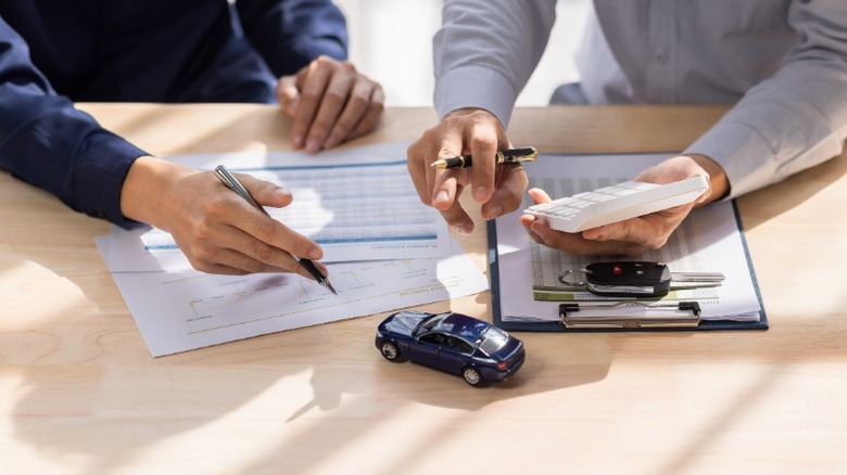 Two people reviewing a car's warranty information