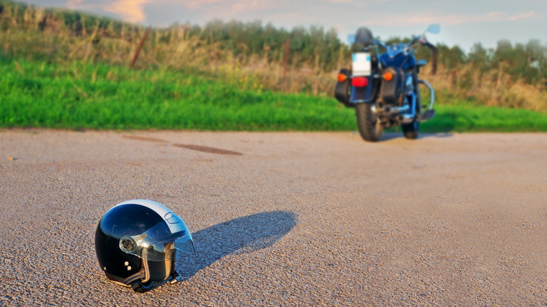 Black and white helmet on the ground behind  motorcycle