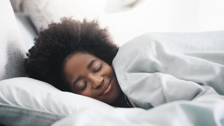 Woman sleeping in her bed in the morning at home