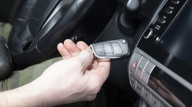 Person with a car key fob inside a car