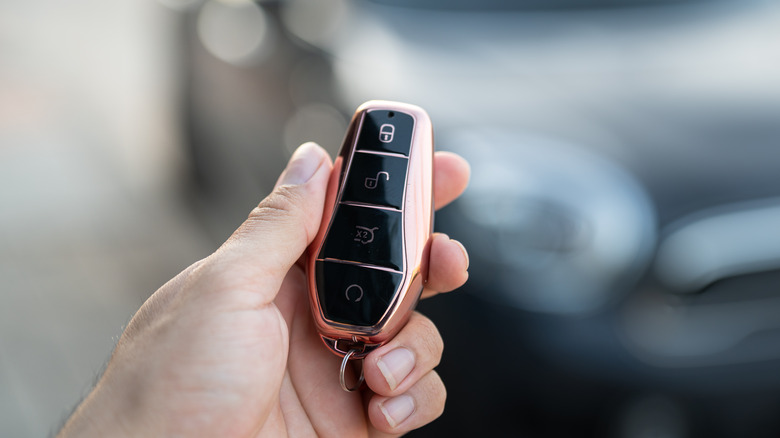 Hand holding a modern-day key fob for cars