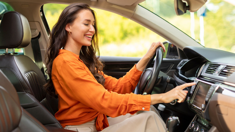 Person touching the dashboard of a car while driving.