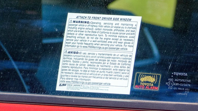 A Prop 65 warning label on a car window