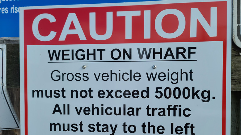 A red and white sign cautioning weight limits