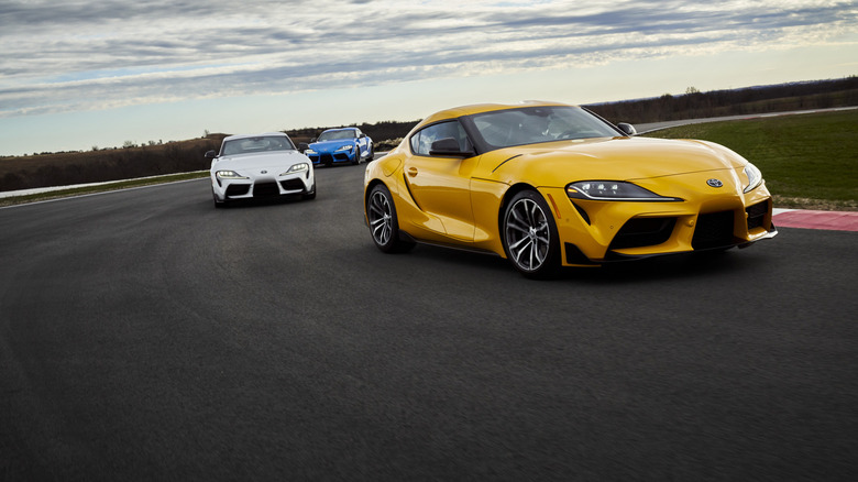 Three Toyota GR Supras driving around a racetrack