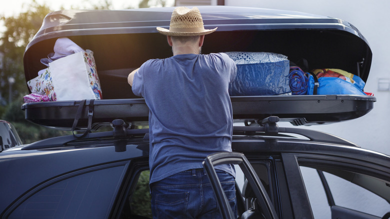 Man loading things on top of car