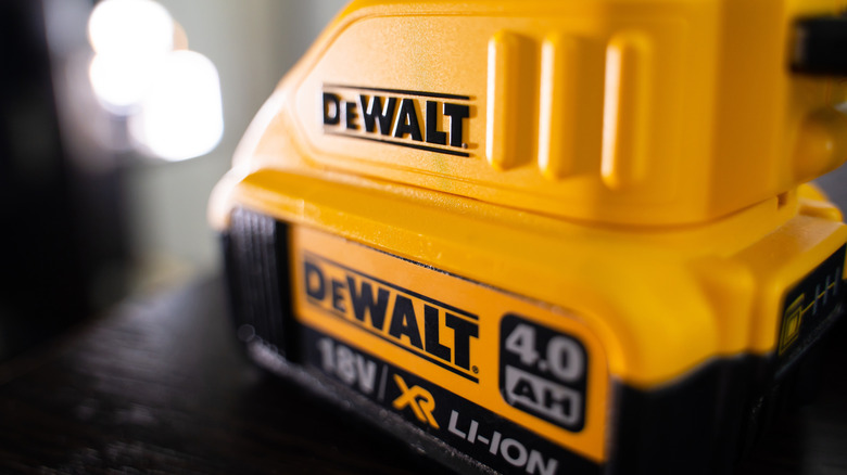 A yellow DeWalt battery plugged into a charger.